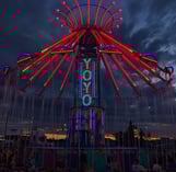 a carnival ride at night with people sitting on chairs