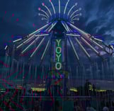 a carnival ride at night with people sitting on chairs