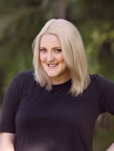 a woman with blonde hair and a black top