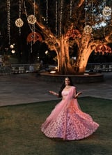 a woman in a pink dress and a tree with lights