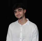 a man in a white shirt and tie dye on a black background