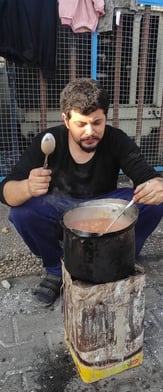 a man is cooking in a potted potted on a stove