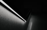 a black and white photo of a stair railing with a light