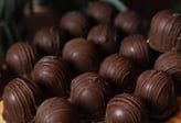 Uma deliciosa seleção de bombons de chocolate dispostos em uma superfície de madeira, destacando a f