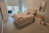 a second bedroom with a bed and a chair