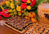 Deliciosos doces decorados com chocolate e cobertura de amendoim, rodeados por flores vibrantes, per