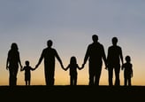 silhouette of an extended family walking along holding hands