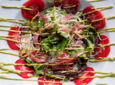 a salad with tomatoes and cheese on a white plate