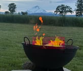 a fire pit with a mountain in the background