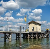 Dingelsdorf am Bodensee – Steg mit kleinem Häuschen und Flagge bei sonnigem Wetter