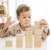 image d'un enfant jouant avec des cubes en bois