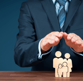 a man in a suit and tie is holding a wooden block with a family icon