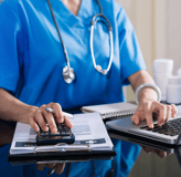 a nurse in scrub scrubs and a stethoscope on a laptop