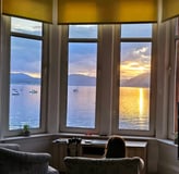 a girl sitting in a chair looking out at the ocean at Gourock Seaview Holiday Let