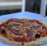 Pizza Sud Ouest avec magret de canard fumé, oignons, tomates,mozzarella sur pâte artisanale fermenté