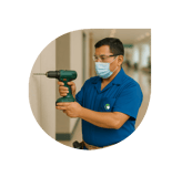 Técnico de NOAM realizando mantenimiento preventivo en instalaciones con taladro eléctrico