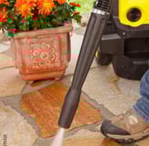 a person using a pressurer to clean a patio