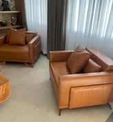 Par de poltronas reformadas em couro marrom e pés de madeira 