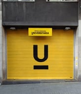 Graffiti en persiana, cierre metálico de Óptica Universitaria, Barcelona
