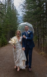 Couple who just got married walking through a forest in Banff