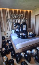 Glamorous 30th birthday room design featuring black and silver balloons and luxury decor.