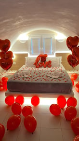 Romantic surprise room setup with heart-shaped balloons for an anniversary celebration.