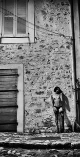 Photo noir et blanc d'une jeune presque nue dans la rue de nuit avec des croix sur les seins