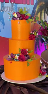 Bolo de três camadas decorado com flores em um evento, com um fundo colorido e vibrante representant