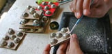 a person is using a pair of scissors to cut a button