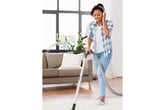 A woman vacuums while listening to an audiobook