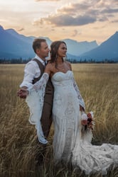 a bride and groom standing in a field