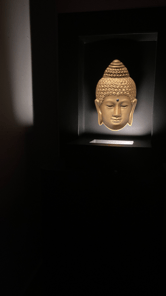 a buddha statue in a dark room with a light on it