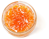 Top-down view of a little, clear, open container of papaya preserves preserves.