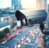 a camera mounted on a wall in a city