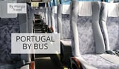 Empty rows of seats in a bus & a sign that says 'Portugal by bus'