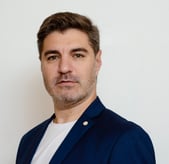 Consultor de marketing digital profesional con blazer azul, fondo blanco.