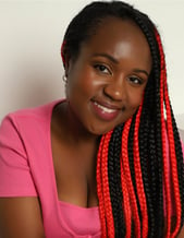 a Black woman with a pink top and cardigan, and black and red hair