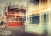 Abstract multiple exposure photograph of a man crossing a street with historic buildings in vibrant colours