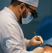 Dr. Adeilson Moreira operando tireoide com lupas cirúrgicas em centro cirúrgico iluminado