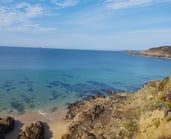 a person standing on a cliff overlooking a body of water