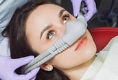 Sedation being administered for a woman in a dental device