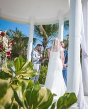 a bride and groom standing in front of a gazeboar