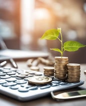 a calculator with a plant growing out of coins