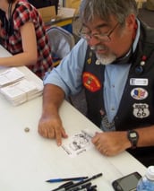Caricature artist drawing biker cartoons at rally.