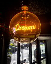 a neon sign that says dream in a glass ball