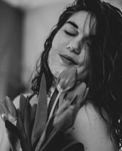 a woman with long hair and a flower in her hands
