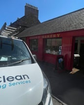 exterior cleaning company van outside local bakery