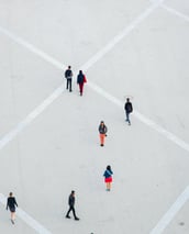 a group of people walking around a square with umbrellas