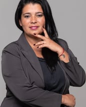 a woman in a gray suit and a red bracelet