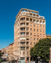 a large building with a lot of windows and a lot of cars parked on the